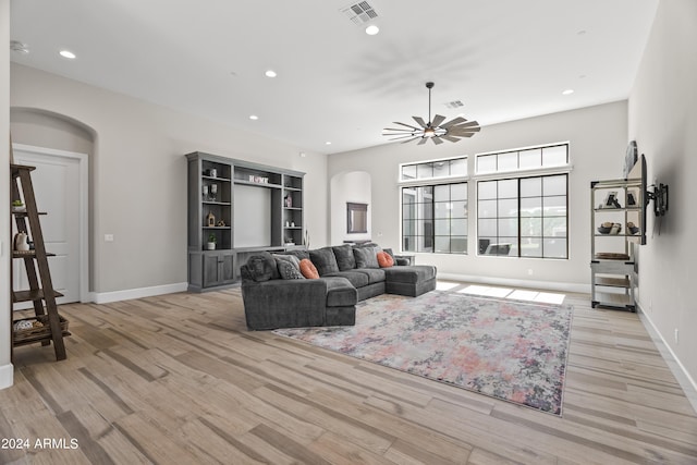 living room with ceiling fan and light hardwood / wood-style flooring