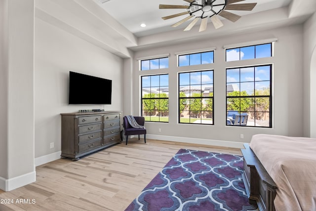 bedroom featuring ceiling fan, light wood-type flooring, and multiple windows