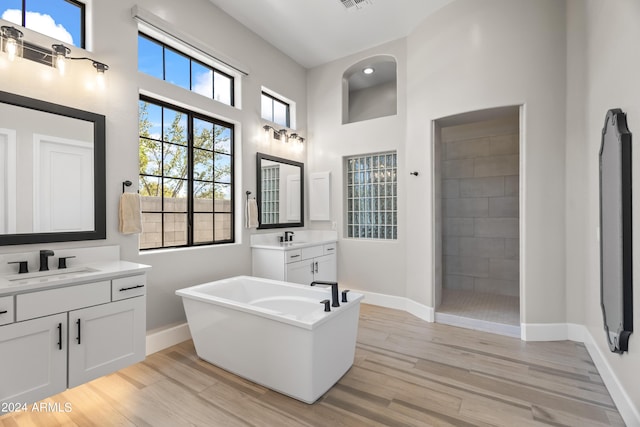 bathroom featuring hardwood / wood-style flooring, independent shower and bath, and vanity