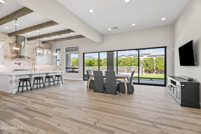 living room with beam ceiling, light hardwood / wood-style floors, and sink