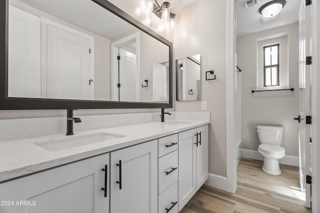 bathroom with toilet, vanity, and hardwood / wood-style flooring