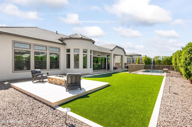 rear view of house featuring a fire pit, a fenced in pool, and a patio area