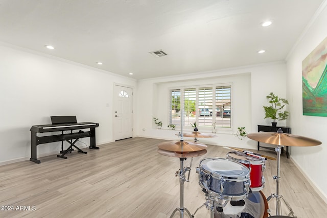 interior space featuring light wood-type flooring and crown molding