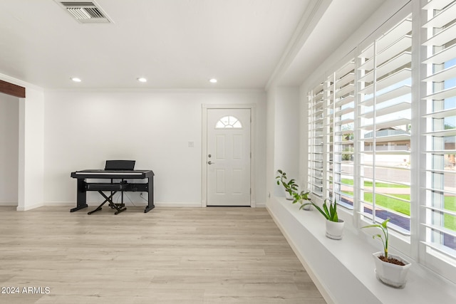 foyer entrance featuring ornamental molding and light hardwood / wood-style floors