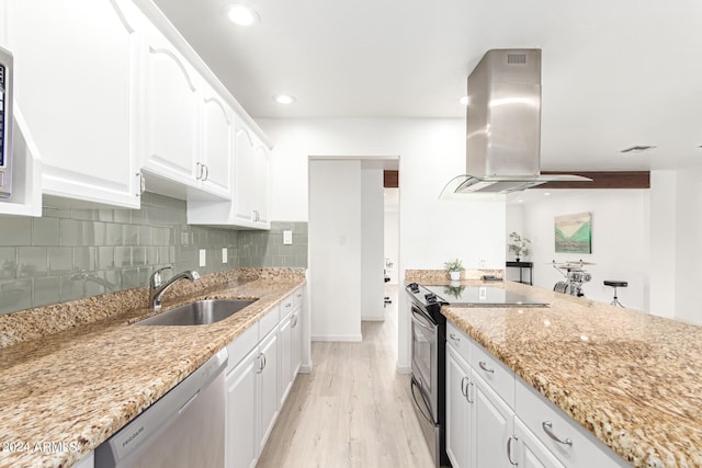 kitchen with light hardwood / wood-style flooring, appliances with stainless steel finishes, light stone countertops, white cabinetry, and sink