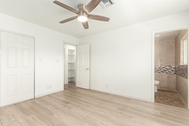 unfurnished bedroom featuring ceiling fan, ensuite bathroom, and light hardwood / wood-style flooring