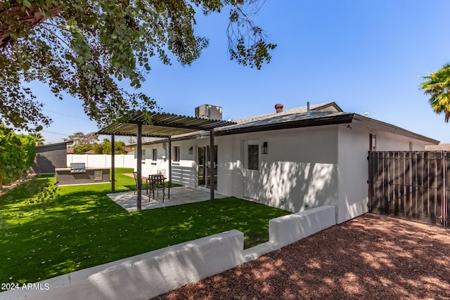 back of house with a pergola, a patio area, and a yard