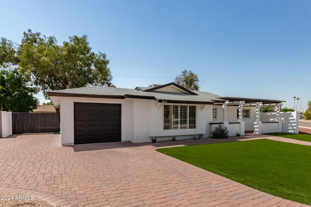 single story home featuring a garage and a front lawn