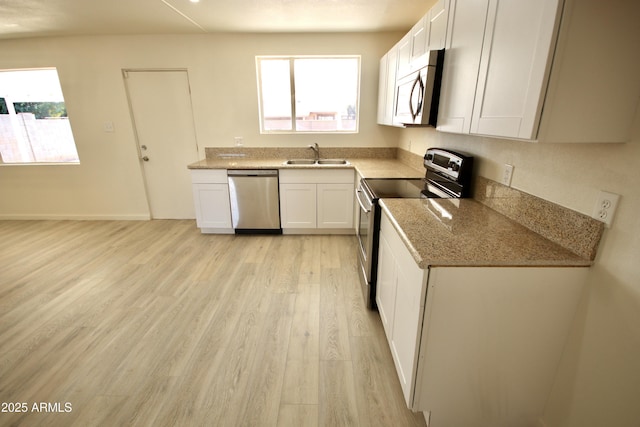 kitchen featuring stainless steel appliances, white cabinetry, sink, and a healthy amount of sunlight