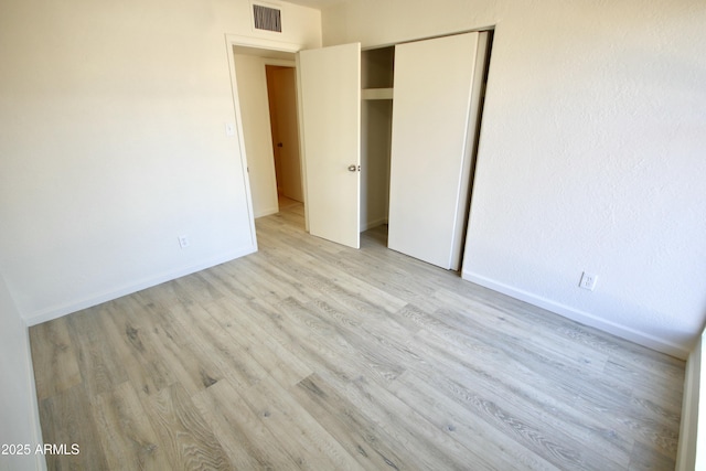 unfurnished bedroom featuring a closet and light wood-type flooring