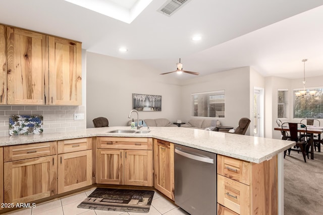 kitchen featuring visible vents, decorative backsplash, a peninsula, stainless steel dishwasher, and a sink