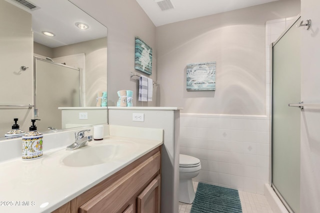 full bathroom featuring a stall shower, visible vents, tile walls, and vanity