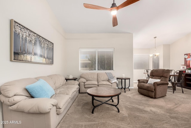 living room featuring ceiling fan with notable chandelier, carpet flooring, and lofted ceiling