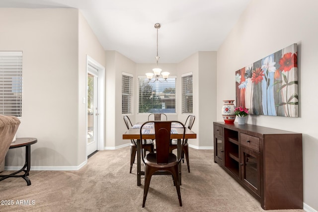 dining area featuring light carpet, baseboards, and a chandelier