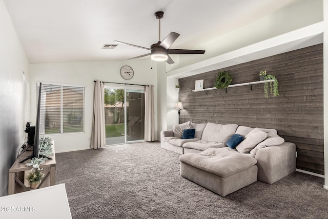 carpeted living room with ceiling fan, lofted ceiling, and wooden walls