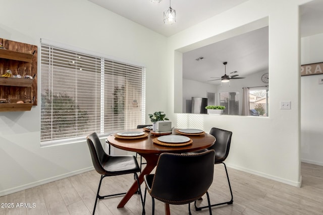 dining room featuring lofted ceiling, light hardwood / wood-style flooring, and ceiling fan