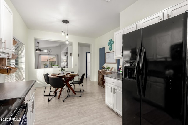 kitchen featuring hanging light fixtures, light hardwood / wood-style flooring, black appliances, and white cabinets