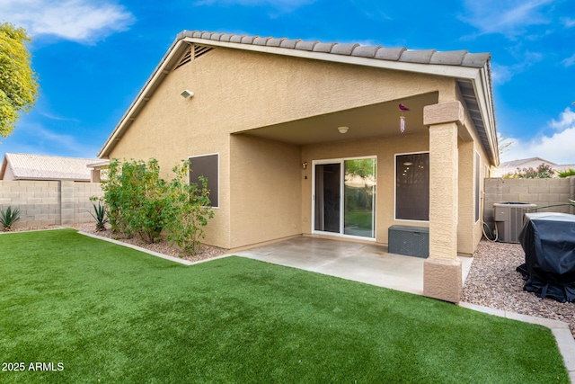 rear view of property with cooling unit, a lawn, and a patio area