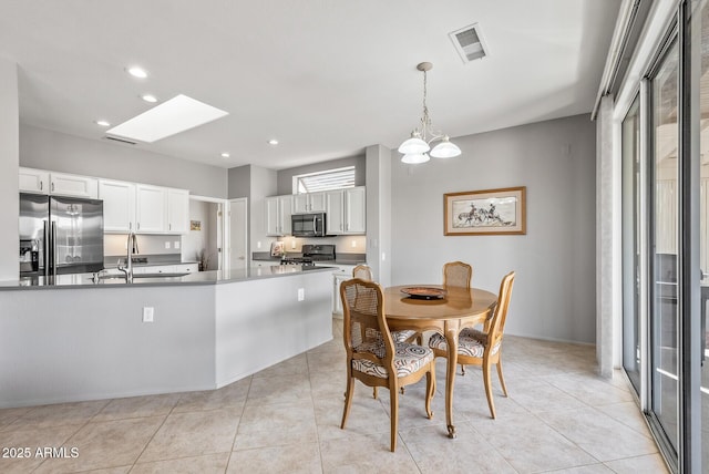 dining area featuring a skylight, light tile patterned floors, visible vents, and recessed lighting