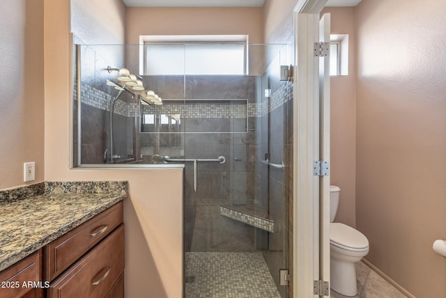 full bathroom with a stall shower, vanity, and toilet