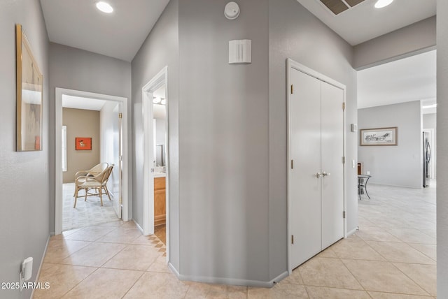 hallway with baseboards and light tile patterned floors