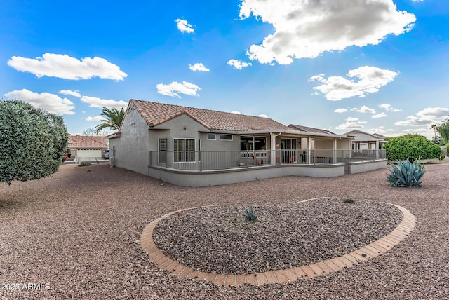 rear view of house featuring a patio, a tiled roof, and stucco siding