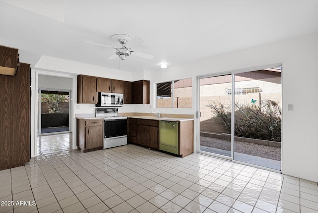 kitchen featuring dishwashing machine, a sink, light countertops, electric stove, and stainless steel microwave