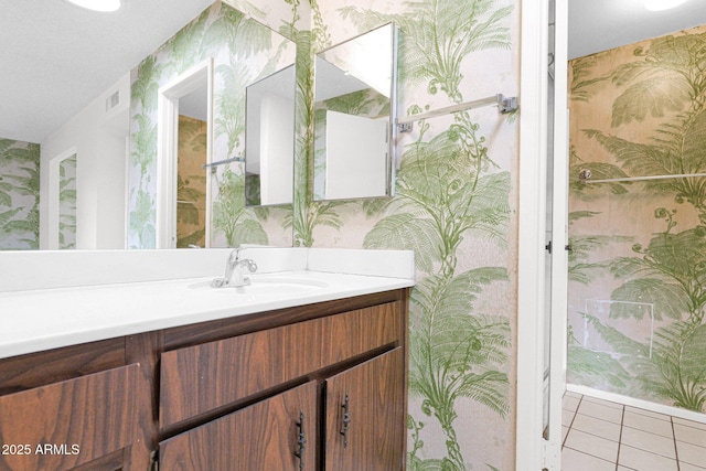 bathroom with wallpapered walls, vanity, and tile patterned flooring