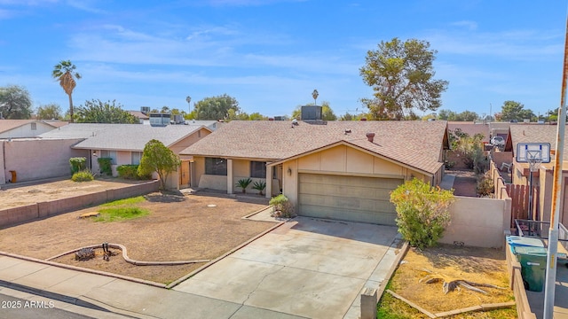 single story home featuring driveway, roof with shingles, a garage, and fence