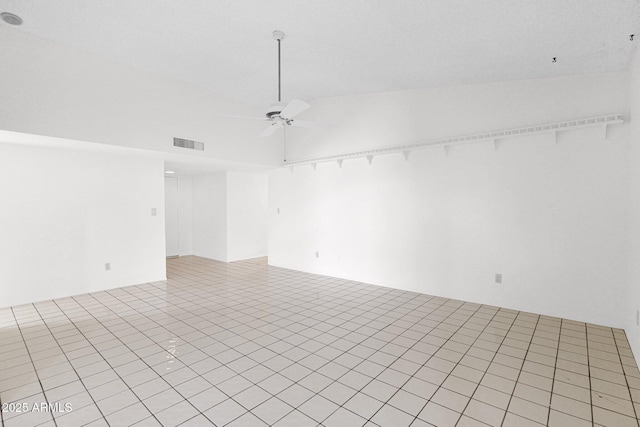 empty room with visible vents, light tile patterned flooring, and a ceiling fan