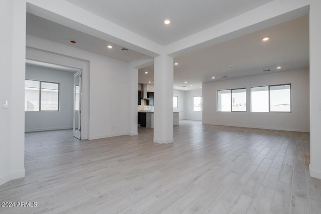 unfurnished living room with light hardwood / wood-style flooring and a healthy amount of sunlight