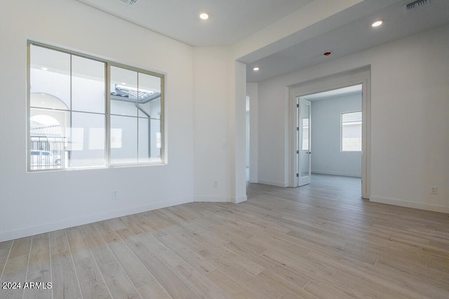 spare room featuring light wood-style floors, recessed lighting, baseboards, and visible vents