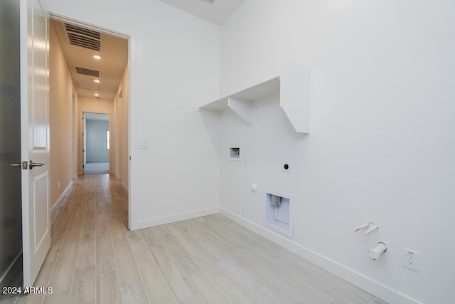 clothes washing area featuring hookup for a washing machine, electric dryer hookup, hookup for a gas dryer, and light hardwood / wood-style flooring