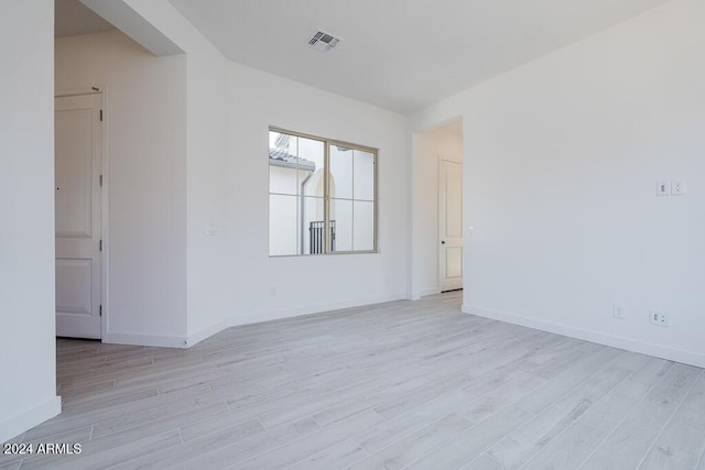 unfurnished room with baseboards, visible vents, and light wood-style flooring