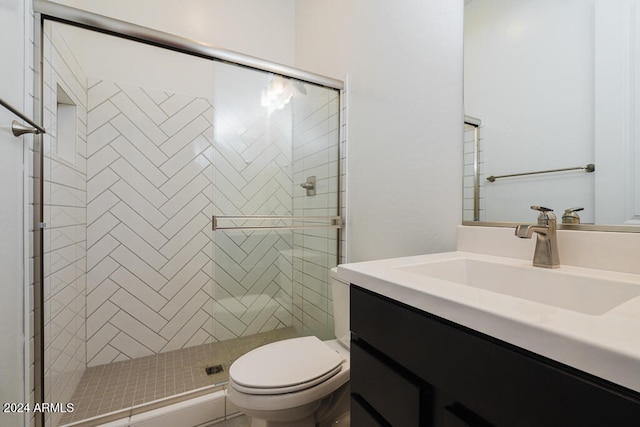 bathroom with toilet, a shower with shower door, and vanity