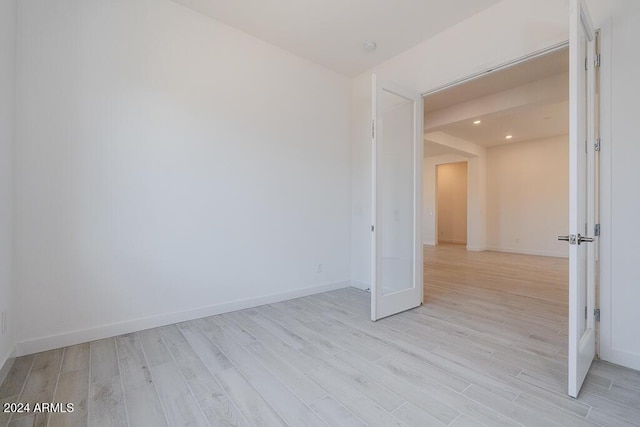empty room with recessed lighting, baseboards, and light wood finished floors