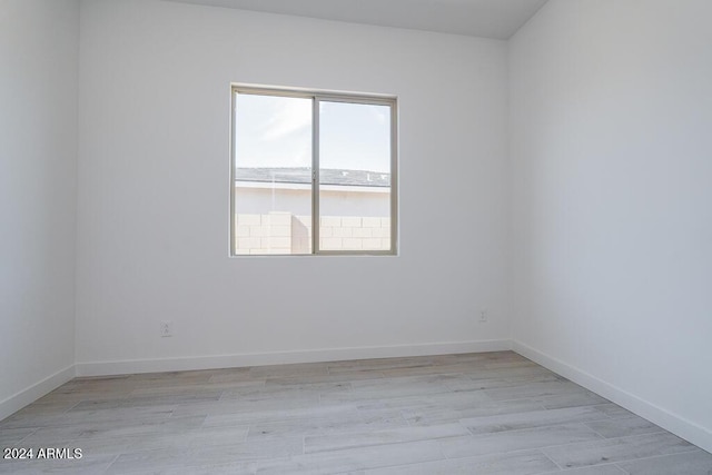 empty room featuring baseboards and light wood-style flooring