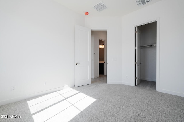 unfurnished bedroom with light carpet and a closet