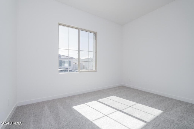 unfurnished room with baseboards and carpet flooring