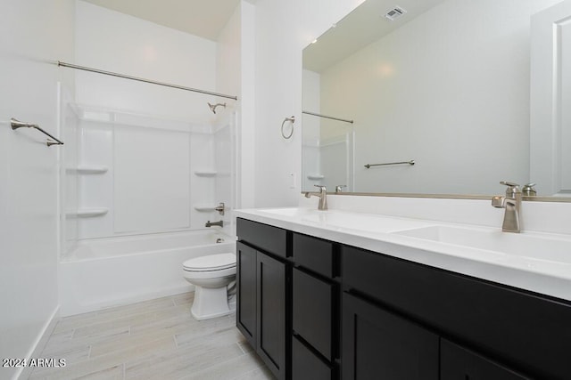 full bath featuring washtub / shower combination, a sink, double vanity, toilet, and visible vents
