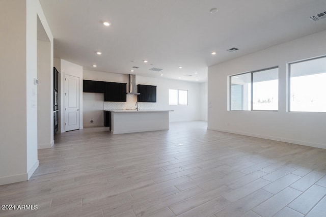 unfurnished living room featuring sink and light wood-type flooring