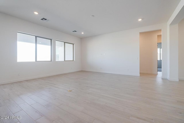 unfurnished room with light wood-style floors, baseboards, recessed lighting, and visible vents