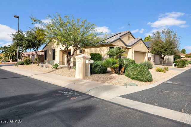 view of front of property featuring a garage and solar panels