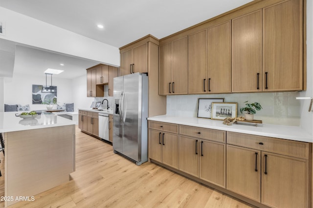 6233 E Pinchot Ave, Scottsdale, AZ 85251 - kitchen featuring stainless steel appliances, light wood finished floors, tasteful backsplash, light countertops, and recessed lighting