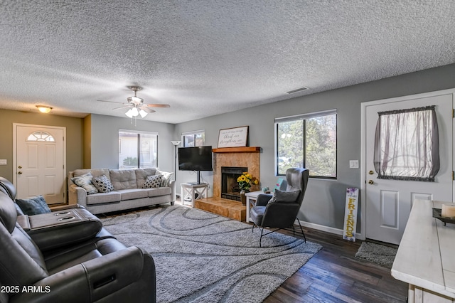 419 Apache Plume Trl, Prescott, AZ 86301 - living area with visible vents, a healthy amount of sunlight, dark wood finished floors, and a tile fireplace