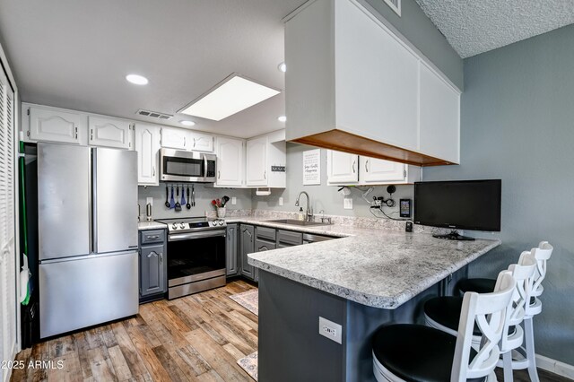 419 Apache Plume Trl, Prescott, AZ 86301 - kitchen featuring visible vents, gray cabinetry, a sink, stainless steel appliances, and a peninsula