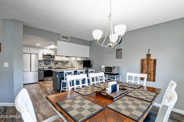 419 Apache Plume Trl, Prescott, AZ 86301 - dining room with visible vents, a textured ceiling, wood finished floors, baseboards, and a chandelier