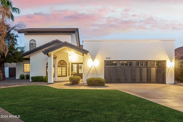 view of front of property with french doors and a yard