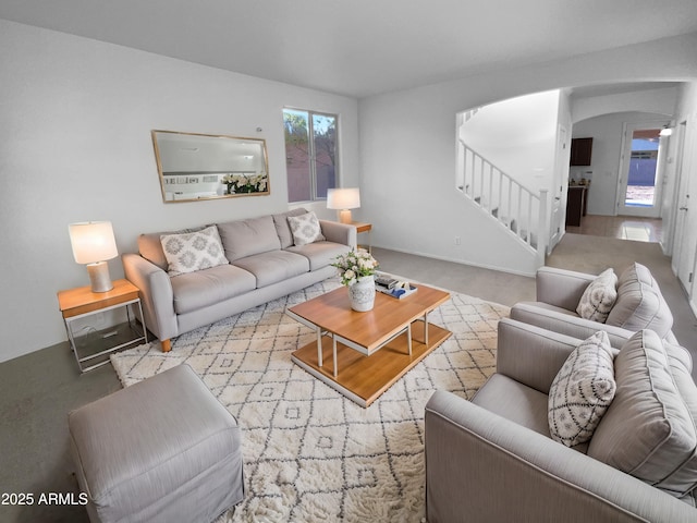 living room with arched walkways and stairs