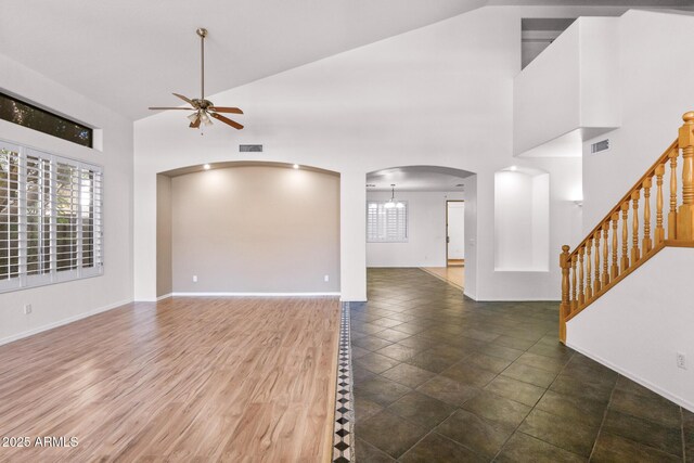 2109 W Wildhorse Dr, Chandler, AZ 85286 - unfurnished living room featuring a ceiling fan, high vaulted ceiling, arched walkways, healthy amount of natural light, and stairway